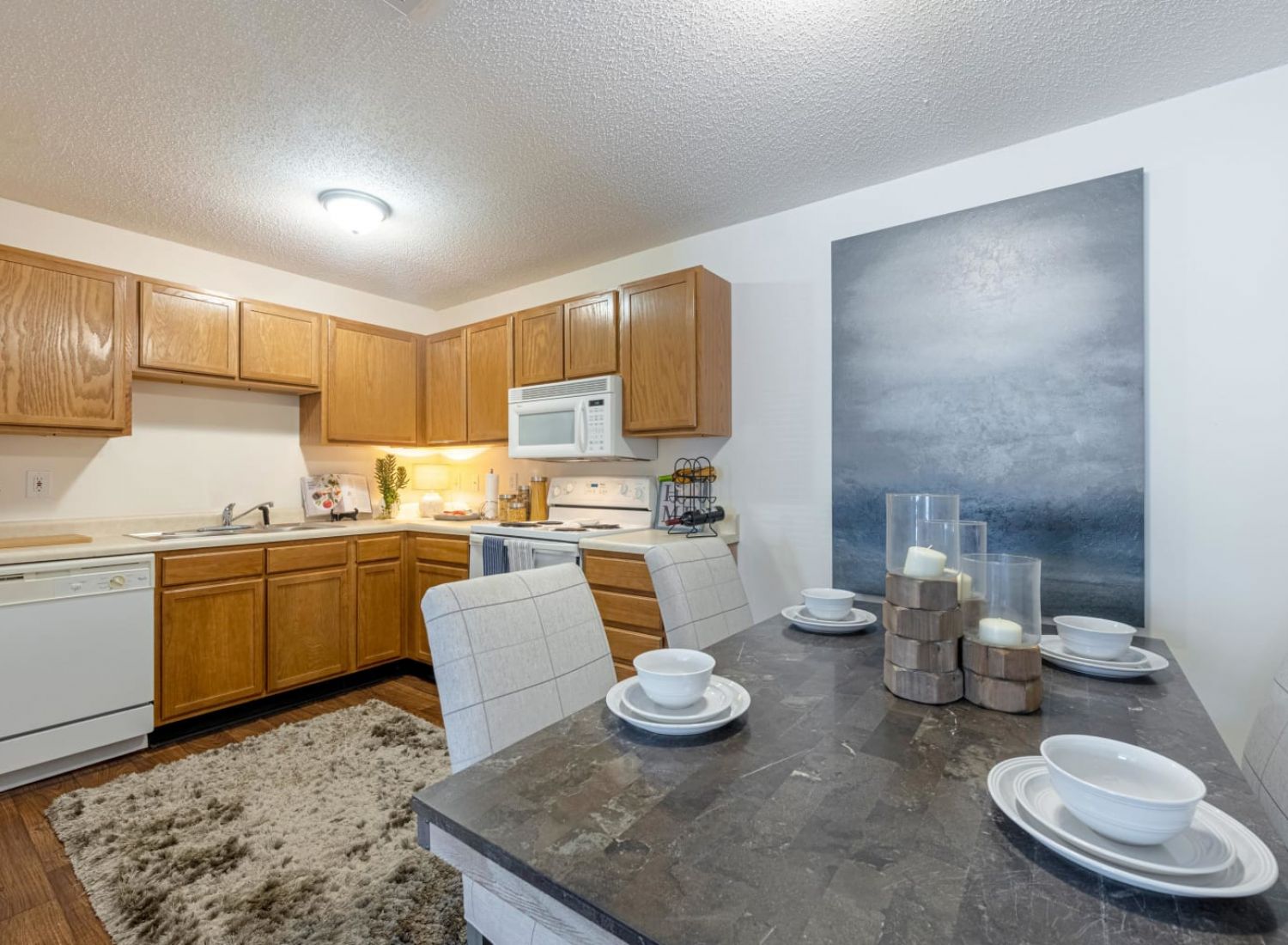 Cozy kitchen and dining area with wooden cabinets, set table, and modern decor.